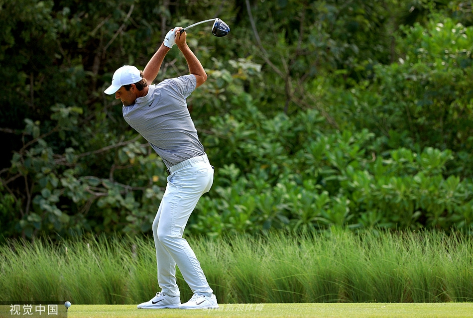 霍夫兰在第十八洞果岭推入制胜一推，握拳庆祝，身后是碧海蓝天与欢呼的观众。