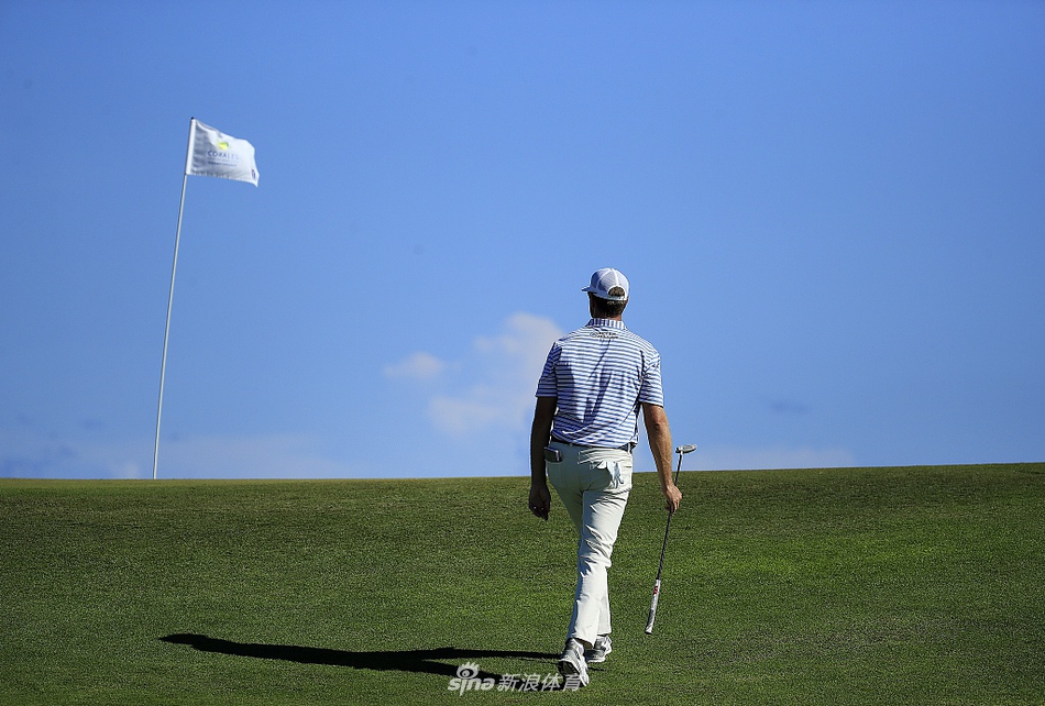 中国名将张新军在全神贯注地观察果岭线路，准备推出精准一杆
