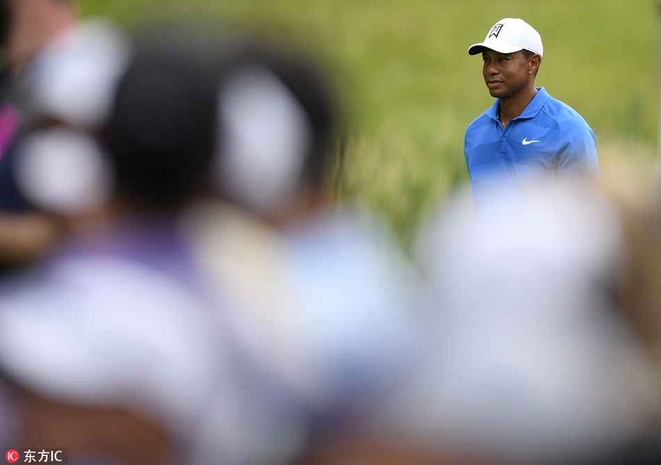 伍兹在赛场边为等候已久的热情球迷签名，脸上带着平和的笑容，展现其作为超级巨星的亲和力。