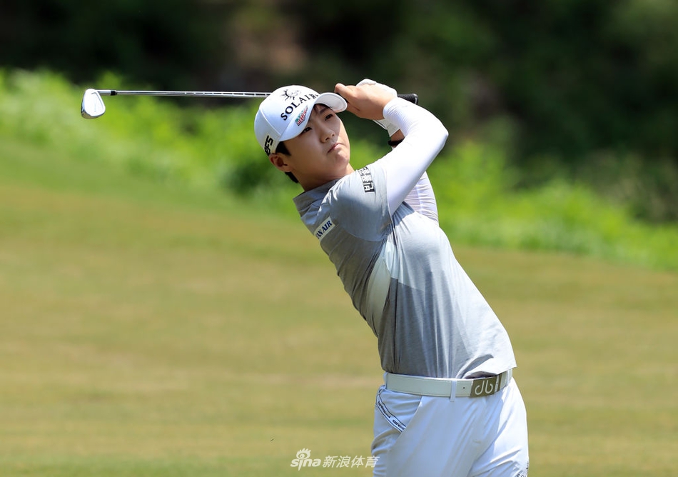 韩国球员朴城炫在发球台上优雅挥杆，阳光洒下勾勒出她充满力量与美感的挥杆弧线。