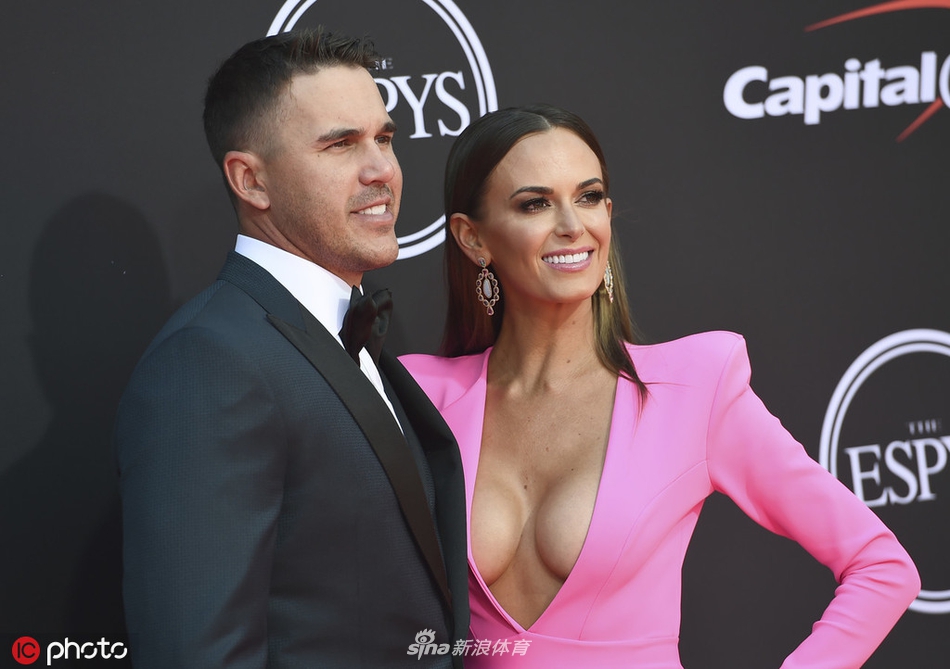 科普卡与女友站在红毯背景板前大方合影，两人站姿优雅，面向不同方向的镜头挥手致意，展现十足默契与明星风范。