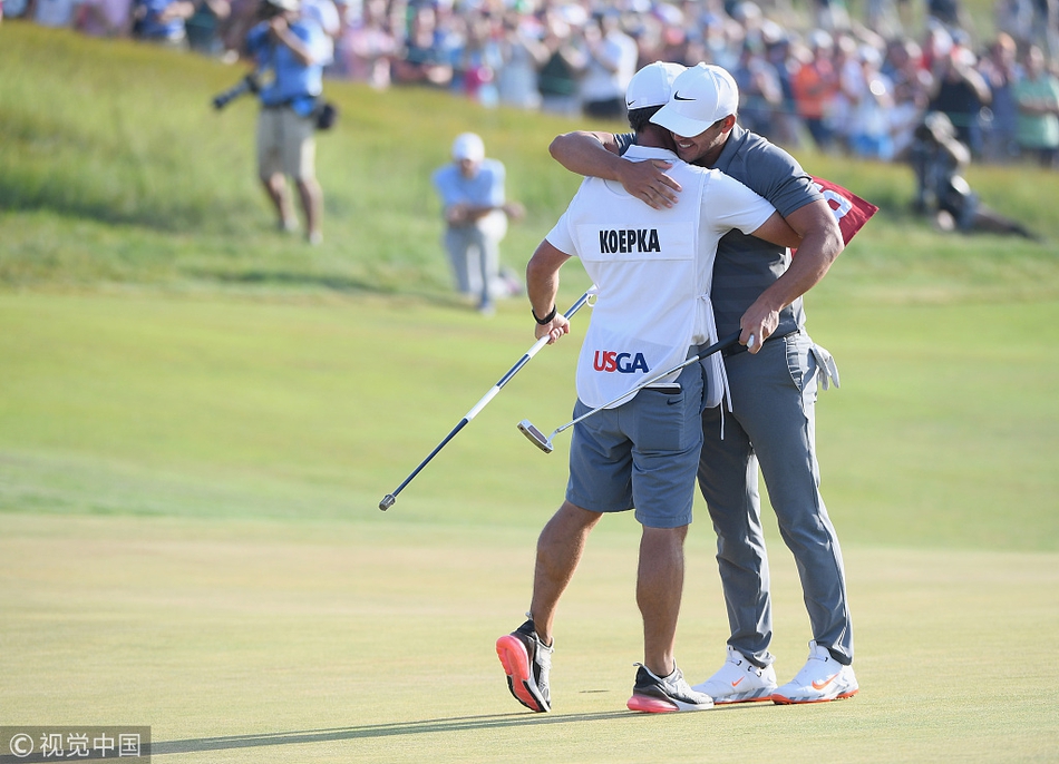 科普卡手捧美国公开赛冠军奖杯开怀大笑，背景中兴奋的球迷们举起手机记录荣耀瞬间。