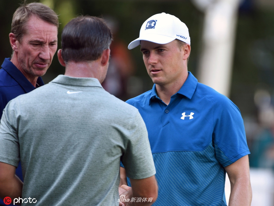 安秉勋在果岭边凝神观察推杆线路，阳光洒在草地上，映衬他专注的侧脸。