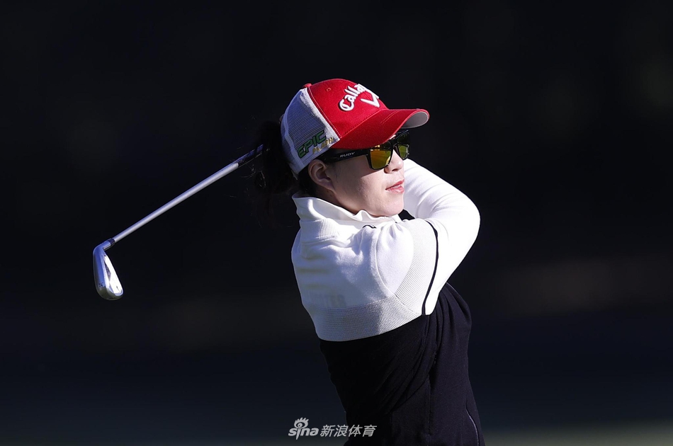 年轻球手周子勤在比赛中露出自信的微笑，手握球杆望向远方，展现出新生代高尔夫球手的朝气与潜力。