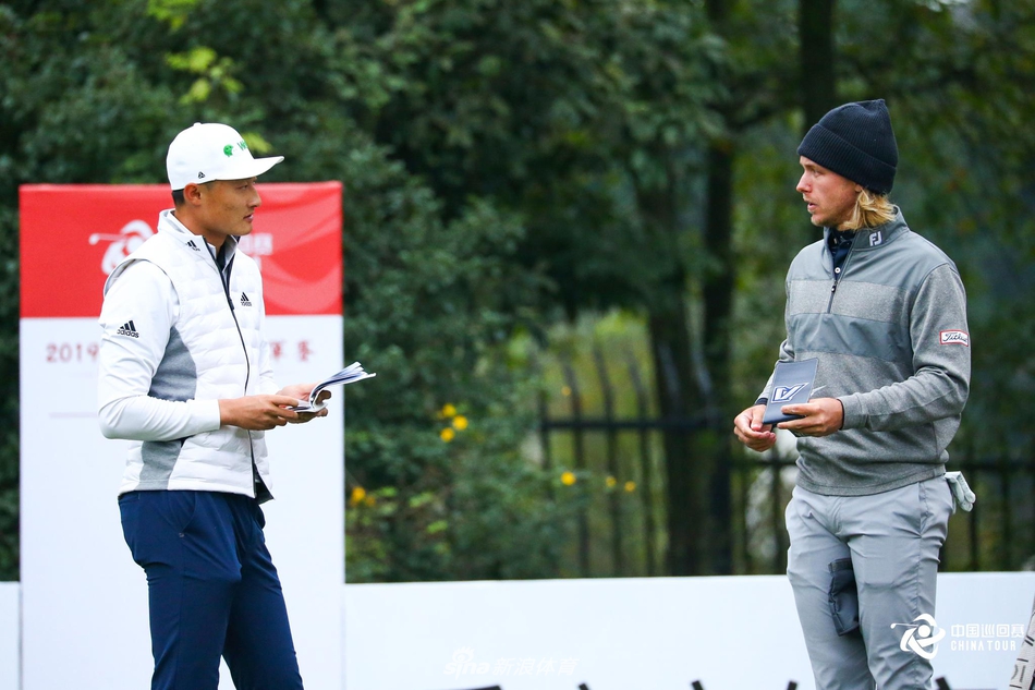 李昊桐与球童在赛场边相视而笑，默契的击掌瞬间，凝聚了并肩作战的信任与即将到来的胜利喜悦。