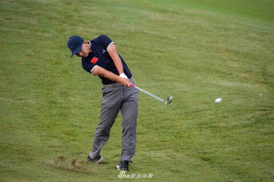 一名球员在沙坑中救球，沙砾飞扬，考验着球员短杆的精准度与临场应变能力。