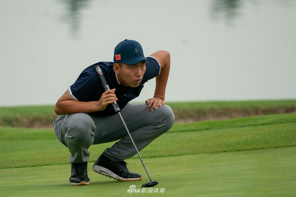 观众聚集在景色优美的水障碍边观看比赛，倒影中赛事氛围与自然景观融为一体。