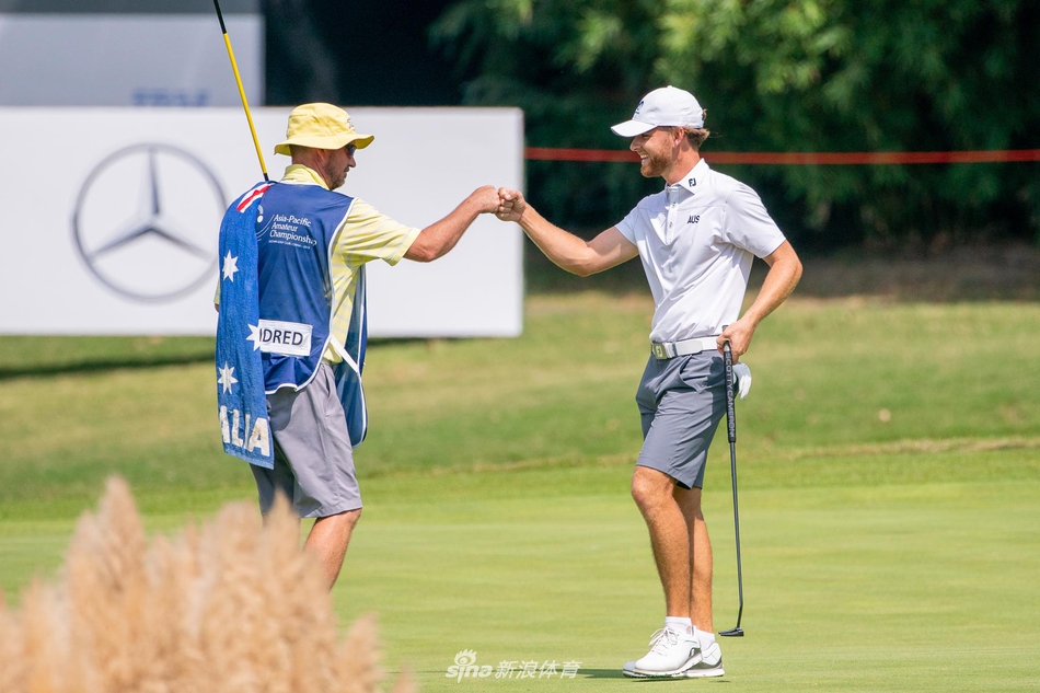 中国球员金博在沙坑中救球,表情坚毅,展现了高尔夫运动永不放弃的精神。