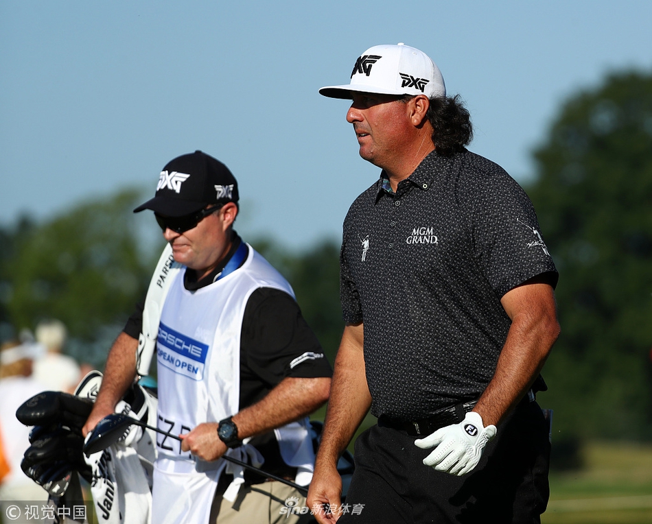 比赛现场观众聚集在果岭周边，聚精会神地观看球员推杆，气氛紧张而热烈