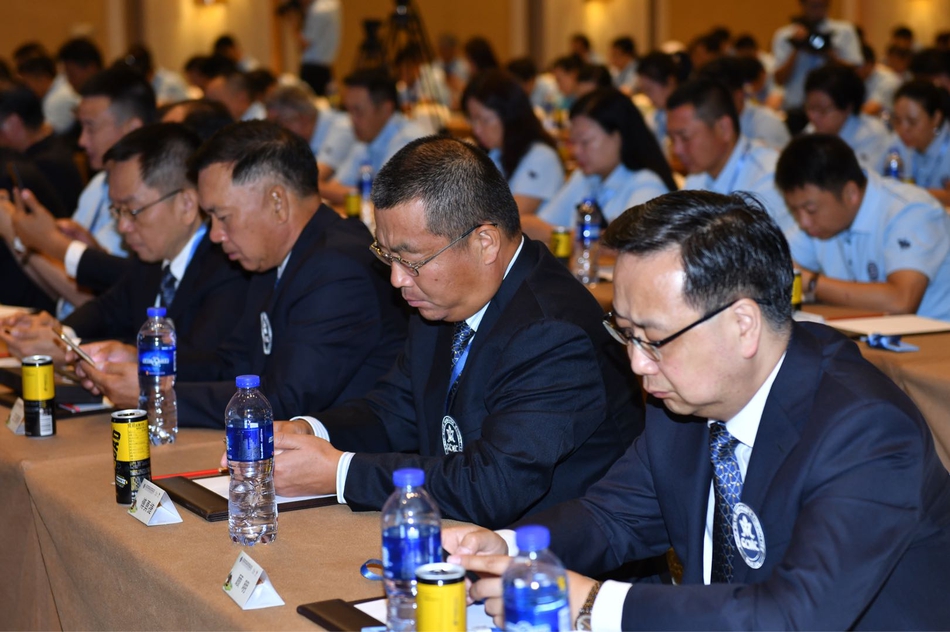 与会嘉宾在茶歇时亲切交谈，手持咖啡杯，脸上洋溢着愉快的笑容，背景是明亮的会议大厅