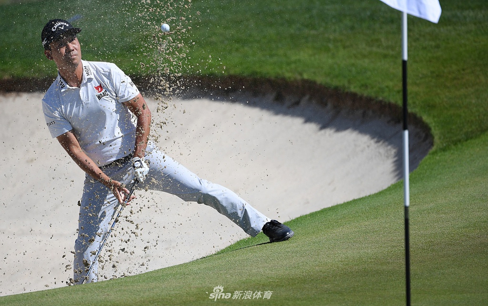 德尚博在沙坑中全力挥杆，沙粒飞扬瞬间充满力量感