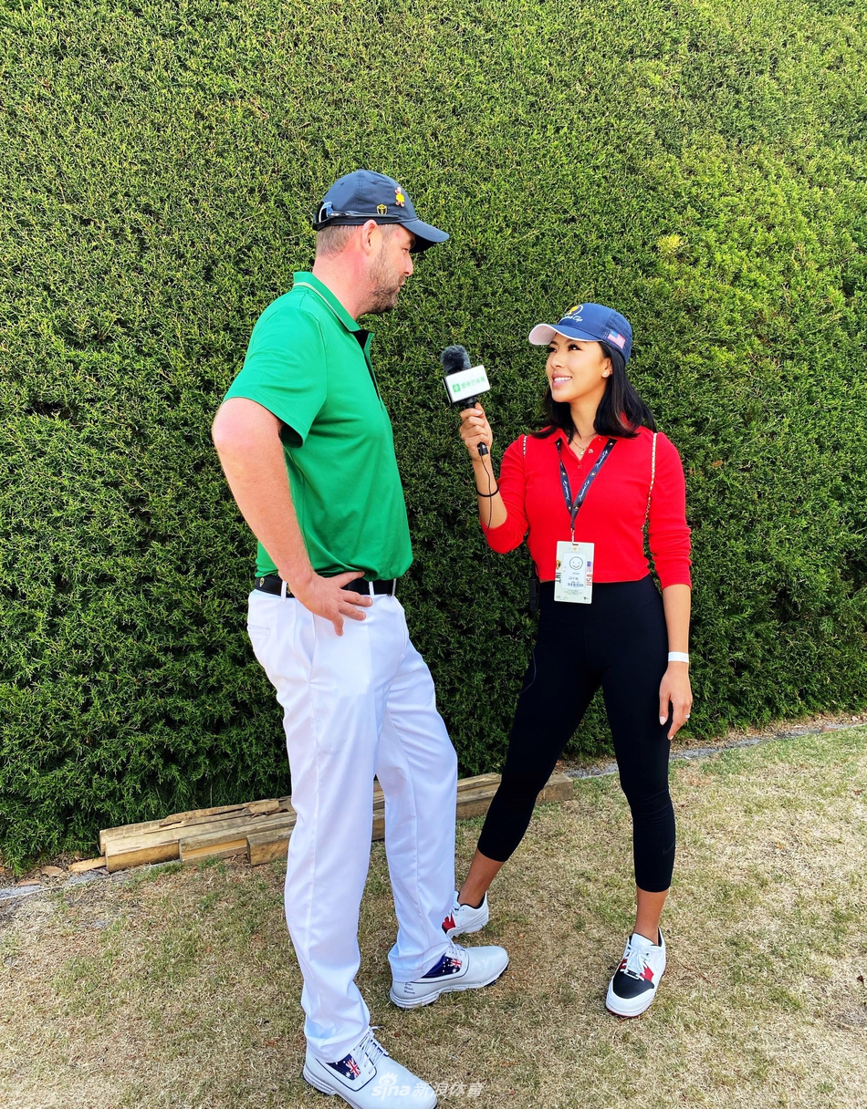 何沐妮手持话筒，以客串记者身份专注地采访国际队高尔夫球员马克·利什曼。