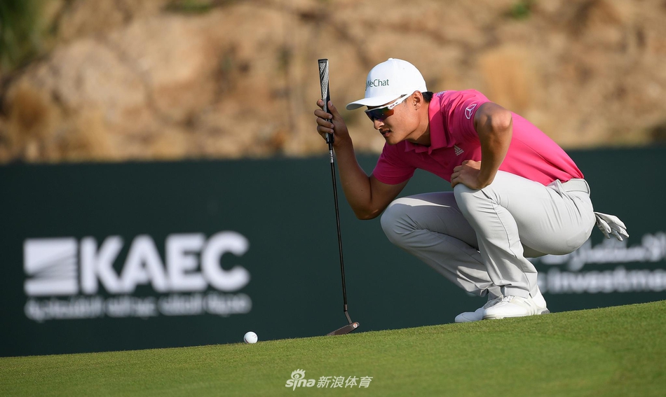 李昊桐与球童在沙坑中并肩观察球位,商讨策略,展现团队合作的默契瞬间。