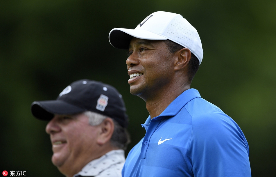 伍兹完成一记漂亮的击球后，自信地抬头追踪小球飞行轨迹，眼神锐利充满期待。