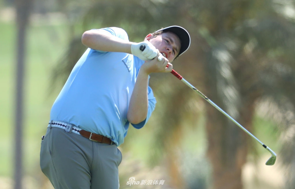 苏格兰球员麦金泰尔在黄昏时分进行长草救球，专注的神情与逐渐降临的暮色构成一幅静谧而激烈的比赛画卷。