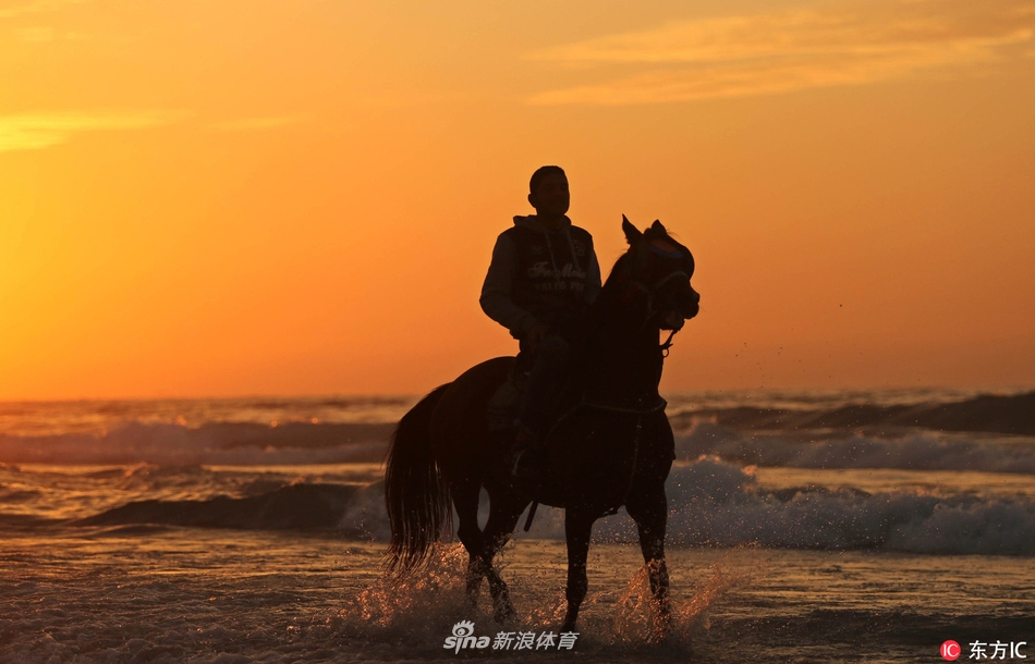 夕阳映衬少年海边骑马