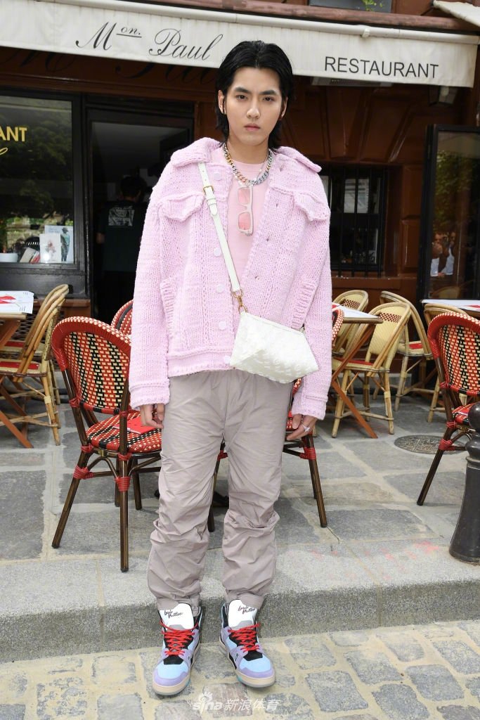 吴亦凡近距离特写，粉紫色毛衫的纹理清晰可见，映衬着他棱角分明的脸庞，眼神中透着一股坚定与从容，仿佛在向世界宣告：时尚无需设限，舒适与自我即是最高准则。