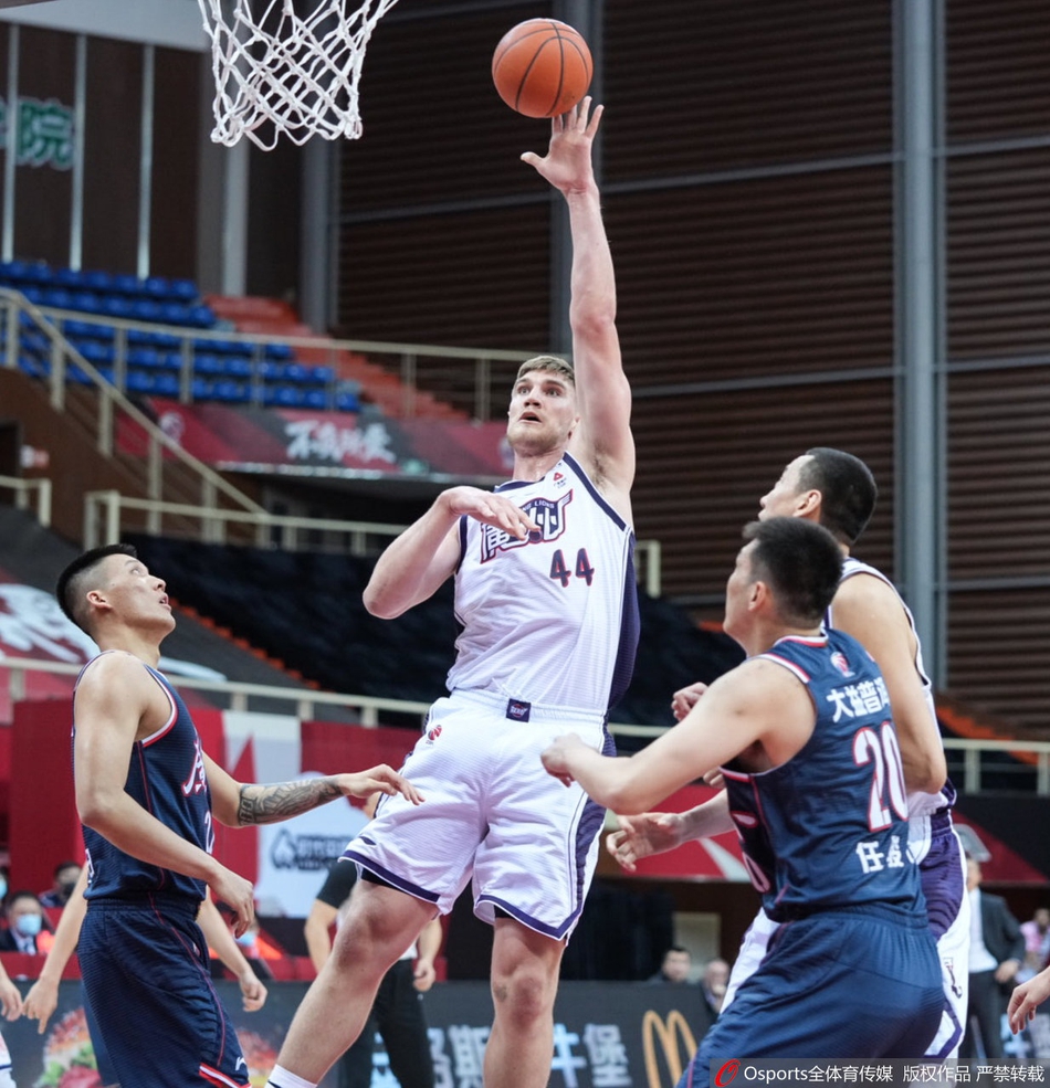 广东宏远队长周鹏在对手的严密防守下，眼神坚毅地持球突破，空气中弥漫着德比大战的火药味。