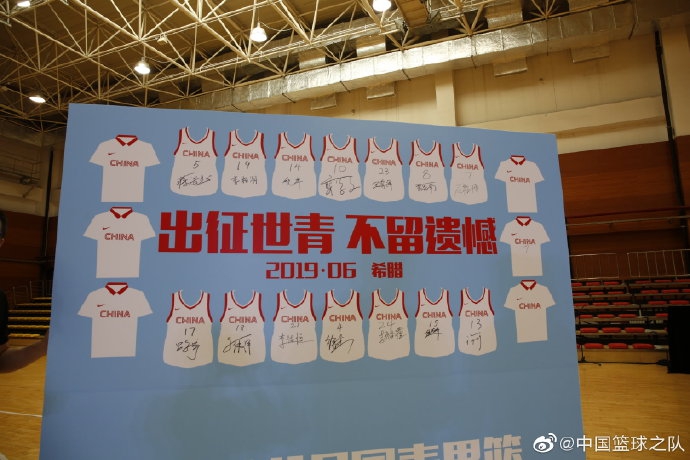 巨大的出征背景板前，一名球员拿起记号笔，在队友的号码旁郑重签下自己的名字，象征着对这次世界杯之旅的庄严承诺。