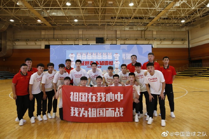 一位父亲与身穿国家队队服的儿子并肩站立，共同展示着刚刚获赠的签名篮球，两人的脸上都洋溢着自豪与幸福的笑容。