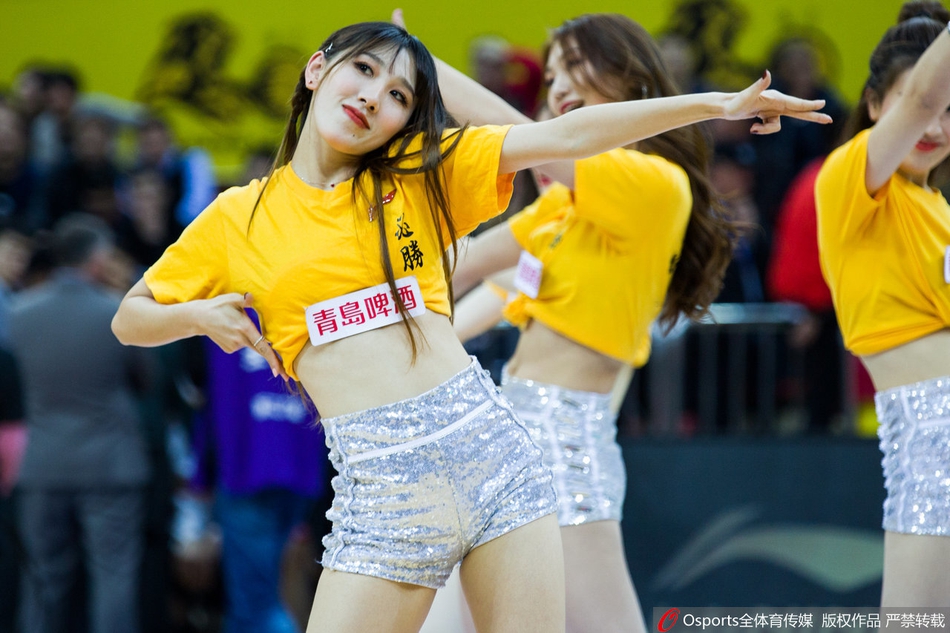 镜头定格在一位篮球宝贝回眸的瞬间,飘逸的长发与专注的眼神交织,她身后的队友们构成整齐的队列,在球场璀璨灯光下宛如一幅动感油画。