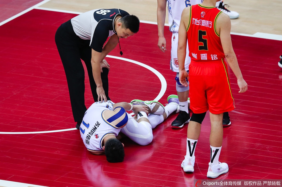 吴冠希坐在更衣室的椅子上，赤脚踩地，左脚踝处有明显的红肿，他双手撑在凳子上，神情疲惫而失落。