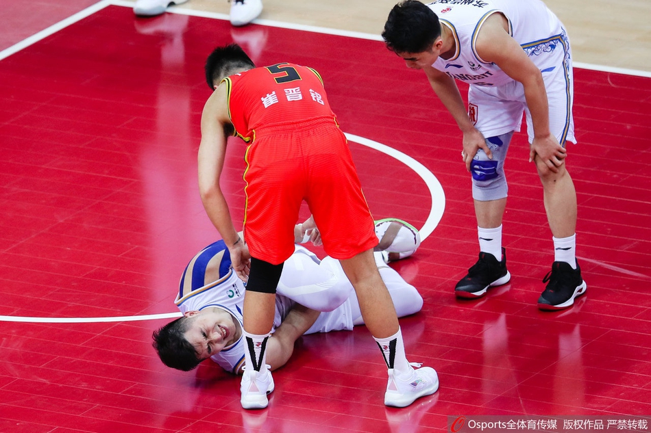 吴冠希在队友和工作人员的保护下，右脚发力，单腿跳着离开赛场，背景是记分牌上98-100的焦灼比分，显得格外落寞。