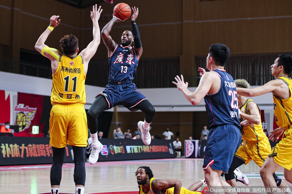 广东外援威姆斯如一道白色闪电，持球强行突破江苏队的防线，他肌肉紧绷，对手的拉扯也无法阻挡他上篮的决心。