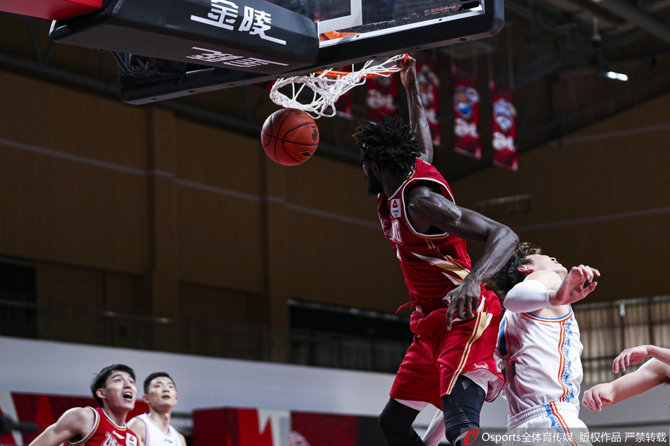 南京同曦外援摩尔特里在长人丛中奋力起跳，用指尖将篮板球拨向自己，他的肌肉线条因为发力而显得格外分明，展现了惊人的篮板统治力。