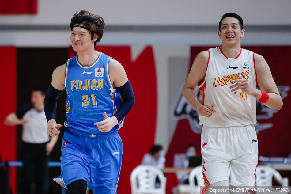 王哲林在深圳队的重重包围下，如同巨塔般强起摘得前场篮板，眼中燃烧着必胜的火焰。