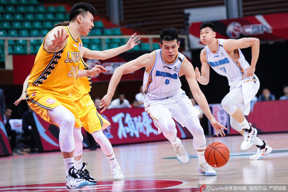 北京队球员张才仁在广厦队员的严密防守下强行出手投篮，身体在空中尽力舒展，只为能为球队贡献宝贵的分数。