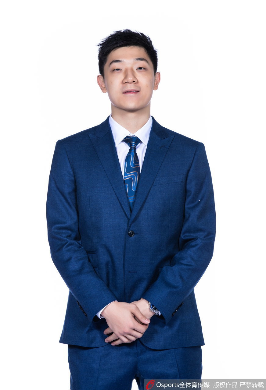 主教练吴庆龙双手抱臂，目光如炬地望向远方，他的身后是整装待发的弟子们，这一刻的沉稳与威严，预示着他将带领这支全新战舰劈波斩浪。