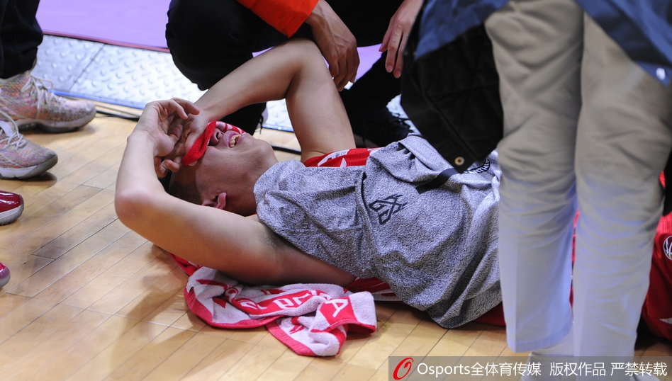巨大的担架被抬进场内，丁皓然躺在上面一动不动，工作人员神情严肃地将他抬起，周围是沉默的球员和教练，场面令人无比揪心。