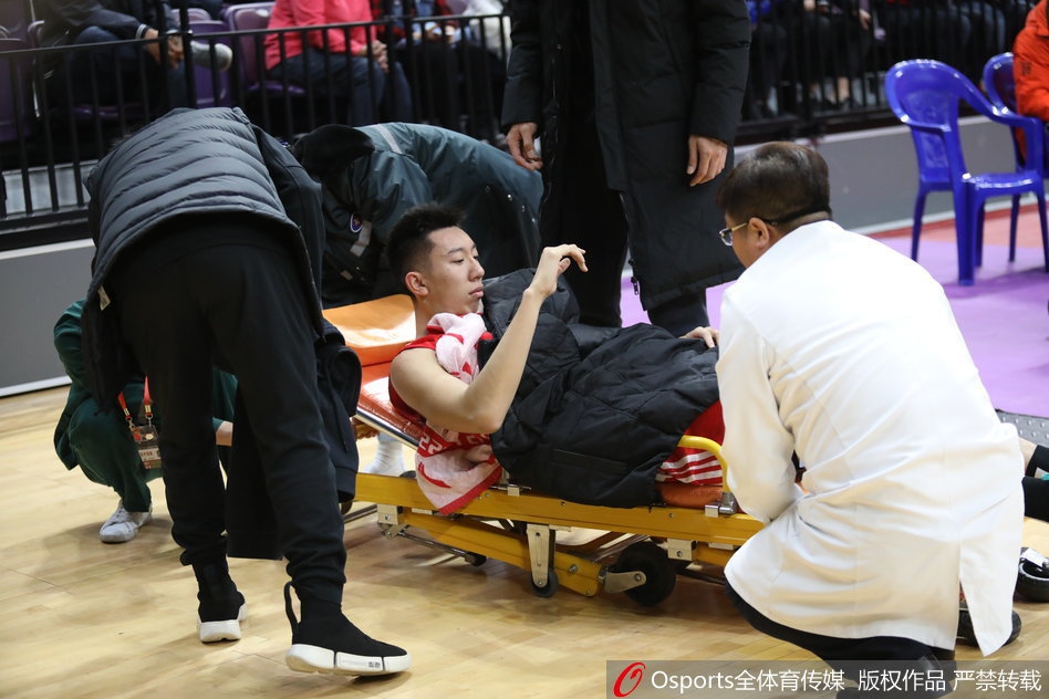 丁皓然痛苦倒地瞬间，手捂膝盖，表情因剧痛而扭曲，身旁的队友们神色慌张，立刻围拢过来查看情况，整个球场气氛凝固。