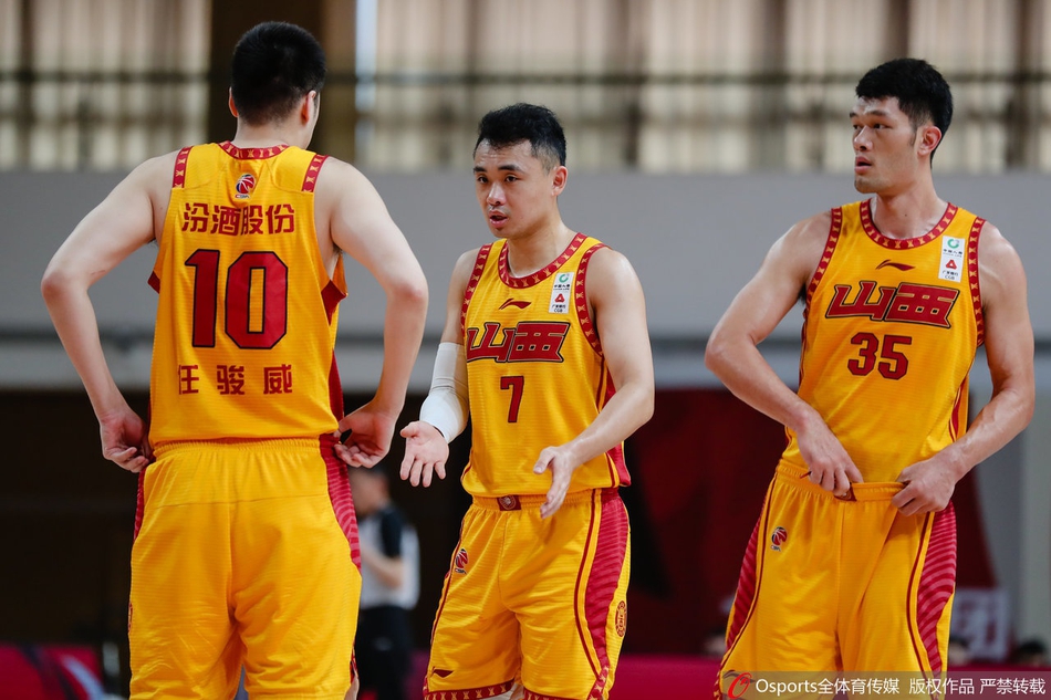 北控主帅在场边激情指挥，双手比划战术，表情严肃而专注，是球队最坚实的后盾