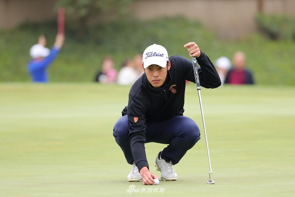 杰弗瑞·姜在成功推杆进洞后，转身与球童击掌庆祝，两人脸上洋溢着默契的笑容