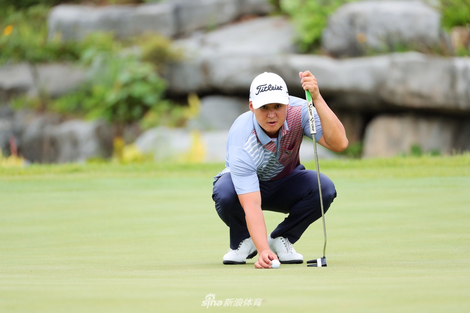 比赛间隙球员与球童认真讨论下一杆策略，手中拿着球场地图