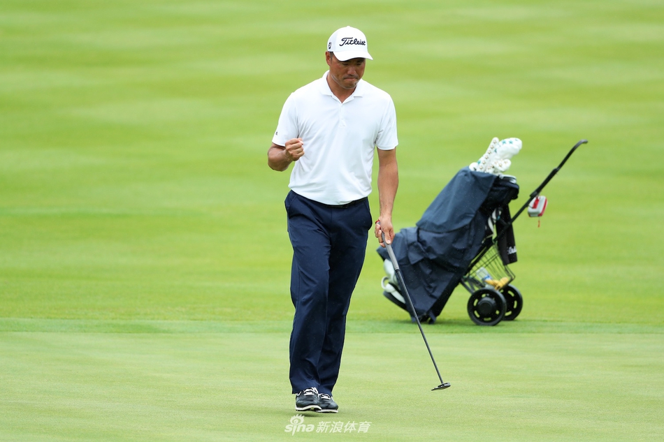 高尔夫球比赛中观众在安全线外凝神观看，背景是连绵的远山