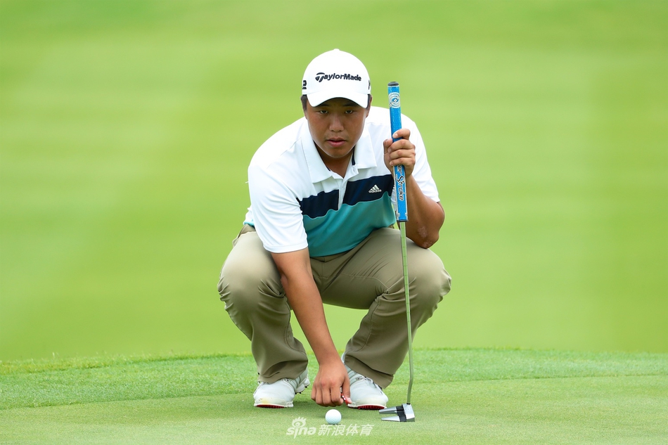 球员在果岭上跪地仔细观察球洞位置，寻找最佳推杆路线