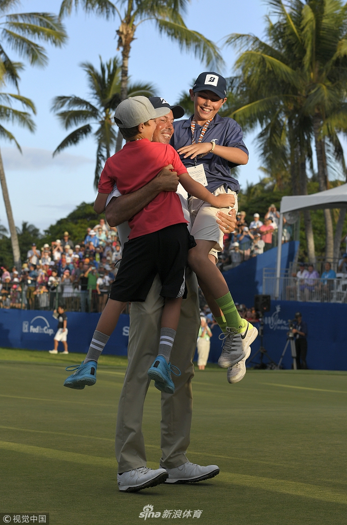 库查尔俯身与年幼的儿子额头相抵,分享胜利的喜悦,父亲的笑容与孩子纯真的眼神构成温馨画面