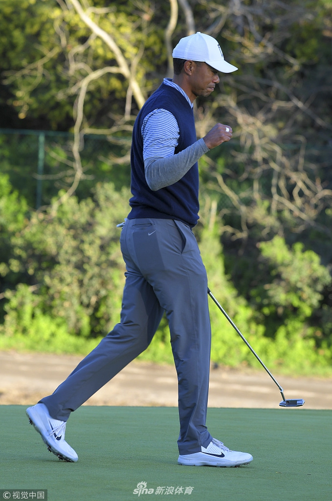 日落时分，伍兹在球道上审视下一杆击球策略，金色的余晖勾勒出他专注的侧影。