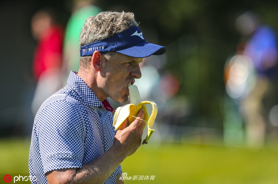 观众聚集在果岭后方山坡上，聚精会神地观看比赛，现场气氛热烈而专注。