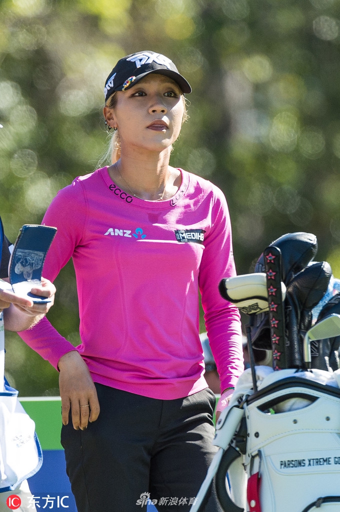 泰国球后阿瑞雅与她的球童在果岭边并肩而行，两人手指向远方，似乎正在认真讨论下一杆的策略与落点。