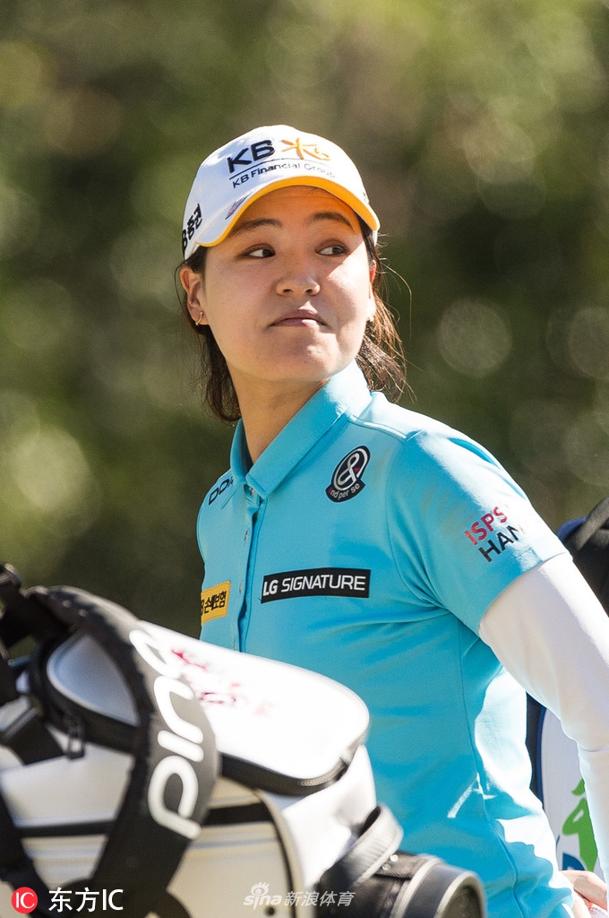 新西兰天才少女高宝璟在果岭上俯身查看推杆线路，表情专注而沉稳，仿佛正在脑海中演练小白球滚入洞杯的轨迹。