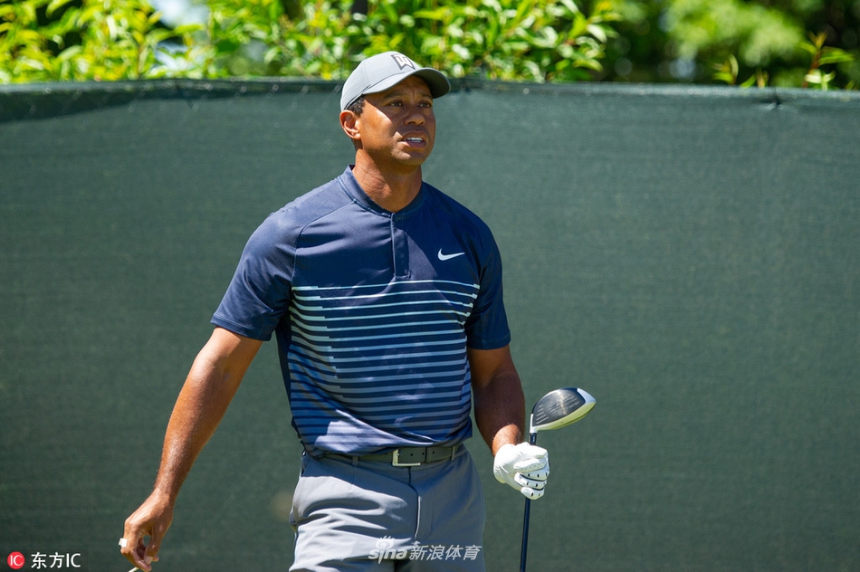 伍兹在长草中处理一记艰难的救球，他降低重心，全神贯注于杆面与球的接触瞬间。