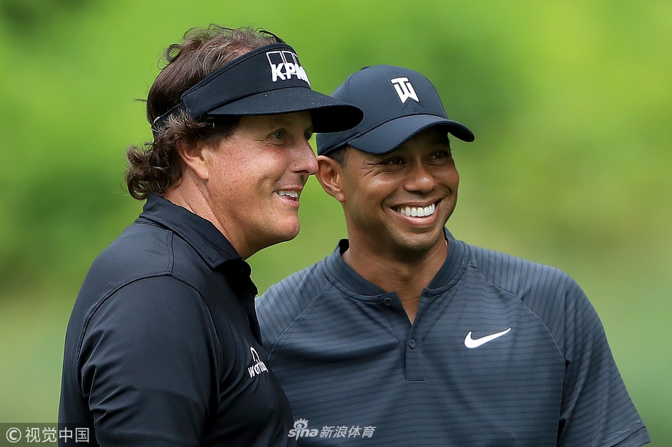 老虎伍兹与菲尔米克尔森在练习轮中并肩行走，阳光洒在球道上，两人神情放松，宛如老友
