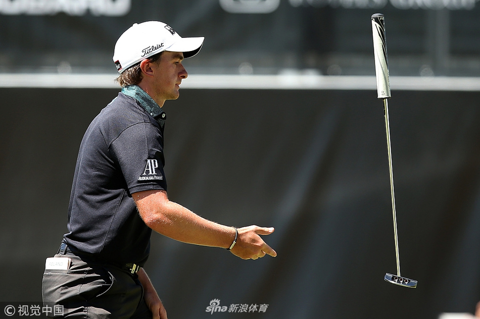 爱尔兰选手保罗-邓恩在果岭上仔细观察推击线路，神情专注，为关键一击做最后准备。