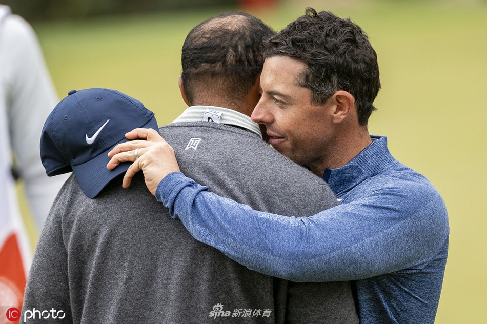 观众聚集在果岭周边，全神贯注地观看伍兹与麦克罗伊的巅峰对决