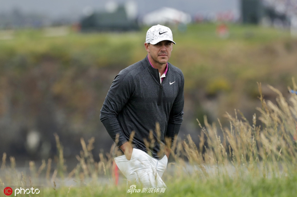 吴璧源与家人在赛场边分享晋级的喜悦，笑容灿烂，背景是圆石滩标志性的海岸松树。