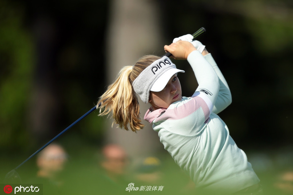 布鲁克·亨德森在梅杰尔精英赛次轮果岭上，眼神专注地审视推杆路线，姿态沉稳自信。